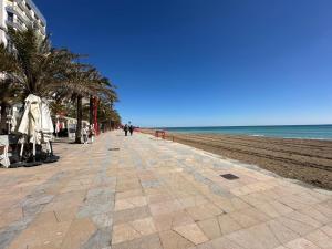 a sidewalk next to a beach with palm trees at AH Rentals in Vinarós