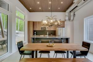 a dining room and kitchen with a wooden table and chairs at Modern Luxury Chalet Private Jacuzzi in La Conception