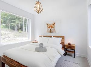 a bedroom with a white bed with a fox head on the wall at Modern Luxury Chalet Private Jacuzzi in La Conception
