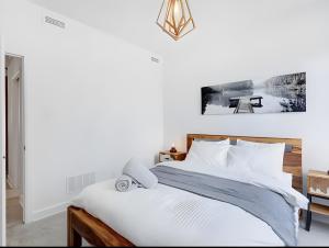 a bedroom with a bed with white sheets and a table at Modern Luxury Chalet Private Jacuzzi in La Conception