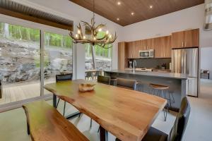 a kitchen and dining room with a wooden table and chairs at Modern Luxury Chalet Private Jacuzzi in La Conception