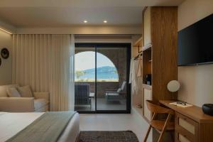 a hotel room with a bed and a view of the ocean at Kelyfos Nafpaktos in Nafpaktos