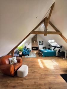 a living room with a couch and chairs in a attic at Chambre d'hote Le clos Valmont in Fécamp