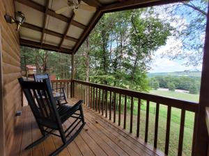 a porch with two rocking chairs and a view at FireFly Acres in Sparta