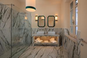 a bathroom with two sinks and two mirrors at Palazzo Saloni in Montalcino