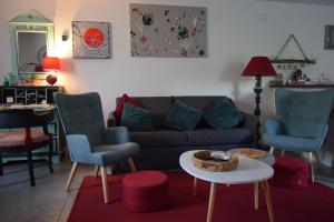 a living room with a couch and two chairs and a table at Gite le GINKGO 50 M2 in Rougegoutte
