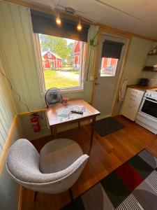 a room with a chair and a table and a window at Daltorps skola, Övernattningsstuga H, Self check in, Übernachtungskabine H in Skövde