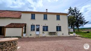a white house with blue windows and a driveway at Clos de Vellerot in Saint-Pierre-en-Vaux