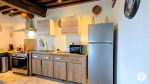 a kitchen with a refrigerator and a microwave at Clos de Vellerot in Saint-Pierre-en-Vaux