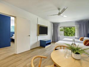 a hotel room with a bed and a table and a tv at Mercure Cairns in Cairns