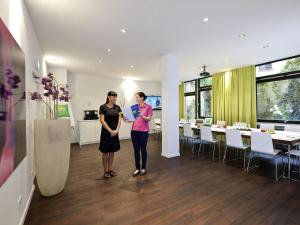 two women standing in the middle of a room at Ibis Styles Frankfurt City in Frankfurt