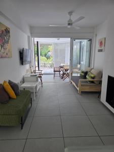a living room with couches and chairs and a television at Yialos Holiday Apartments in Perivolia