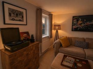 a living room with a couch and a television at Silverstone Paddock Retreat in Silverstone