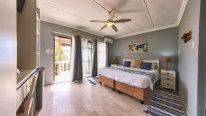 a bedroom with a bed and a ceiling fan at Gracelands Beach Lodge in Ramsgate +163 photos