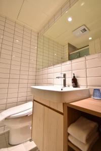 a bathroom with a sink and a toilet and a mirror at Cheng House in Yuchi