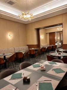 a dining room with tables and chairs and a chandelier at Hotel San Remo in Rome