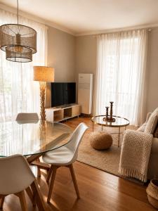 a living room with a glass table and a television at Angoli di pace - Appartamento trilocale in Muralto