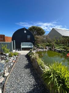 a garden with a bench next to a pond at Taigh Plo in Lionel