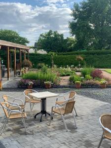 eine Terrasse mit Tisch und Stühlen und ein Garten in der Unterkunft B&B De Vroling in Wellen