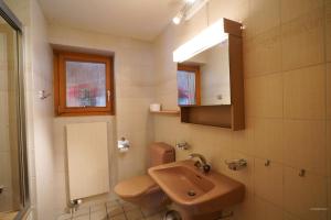 a bathroom with a sink and a toilet and a mirror at Chalet Miravalle 1 in Wengen +16 photos