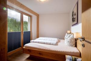 a small bedroom with a bed and a window at Sonnplatzl Appartement Westendorf in Westendorf