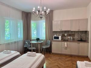 a room with two beds and a kitchen with a table at KUBU namai in Klaipėda