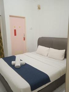 a bed with two towels on top of it at Cozy Highland in Tanah Rata
