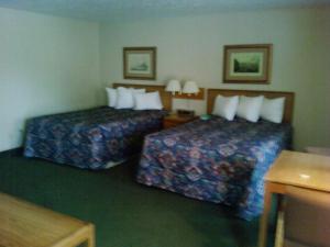 a hotel room with two beds and two lamps at Will Rogers Inn in Claremore
