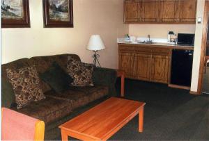 a living room with a couch and a coffee table at Will Rogers Inn in Claremore +15 photos