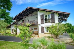 a large white house with a balcony and trees at Amama Baita in Urrugne