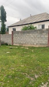 a brick retaining wall in front of a house at House near the mountains in Karakol