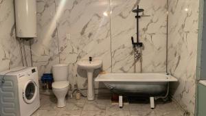 a bathroom with a sink and a tub and a toilet at House near the mountains in Karakol