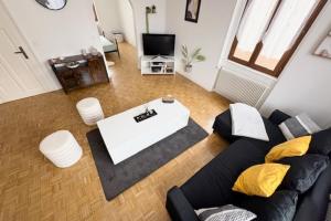 a living room with a black couch and a white table at The Dutt's cocoon spacious and charming T3 in Duttlenheim +36 photos