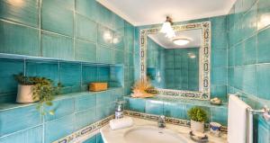 a blue tiled bathroom with a sink and a mirror at AMORE RENTALS - Casa Raffi in Positano +15 photos