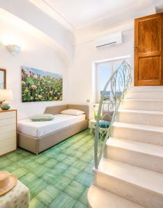 a room with a bed and stairs with a painting at AMORE RENTALS - Casa Raffi in Positano