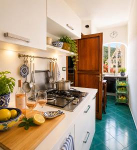 a kitchen with white cabinets and a stove top oven at AMORE RENTALS - Casa Raffi in Positano