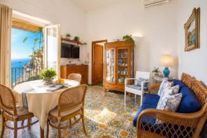 a living room with a table and a blue couch at AMORE RENTALS - Casa Raffi in Positano
