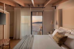 a bedroom with a bed with a view of the ocean at Kelyfos Nafpaktos in Nafpaktos