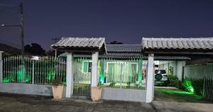 a house with a fence in front of it at night at Casa da Val in Saquarema