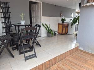 a living room with chairs and a table and a table at Casa da Val in Saquarema