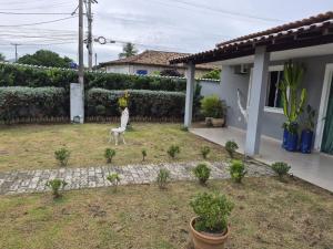 a yard with a statue in front of a house at Casa da Val in Saquarema