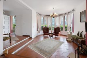 a living room with a table and chairs and windows at Casa Carmen in Cabouco