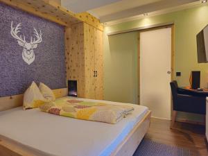 a bedroom with a bed with a wall with a deer head on it at Gasthof Gosausee in Gosau
