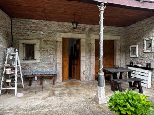 a stone house with a table and a ladder at Apartamentos Dos Aguas in Aguasmestas