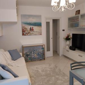 a living room with a white couch and a tv at B&B El Dorado in Lido di Pomposa