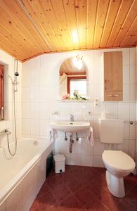 a bathroom with a sink and a tub and a toilet at Aparthotel Bergkristall in Brand +81 photos