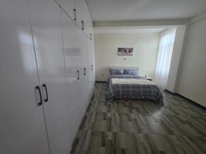 a bedroom with a bed and a large white closet at Goldsip lounge in Addis Ababa