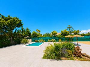 a swimming pool in a yard with an umbrella at Casa el Jilguero Conil in Conil de la Frontera
