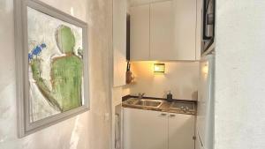a kitchen with a sink and a painting on the wall at Le Duplex in Denicé