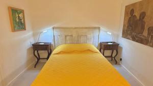 a bedroom with a yellow bed with two night stands at Le Duplex in Denicé